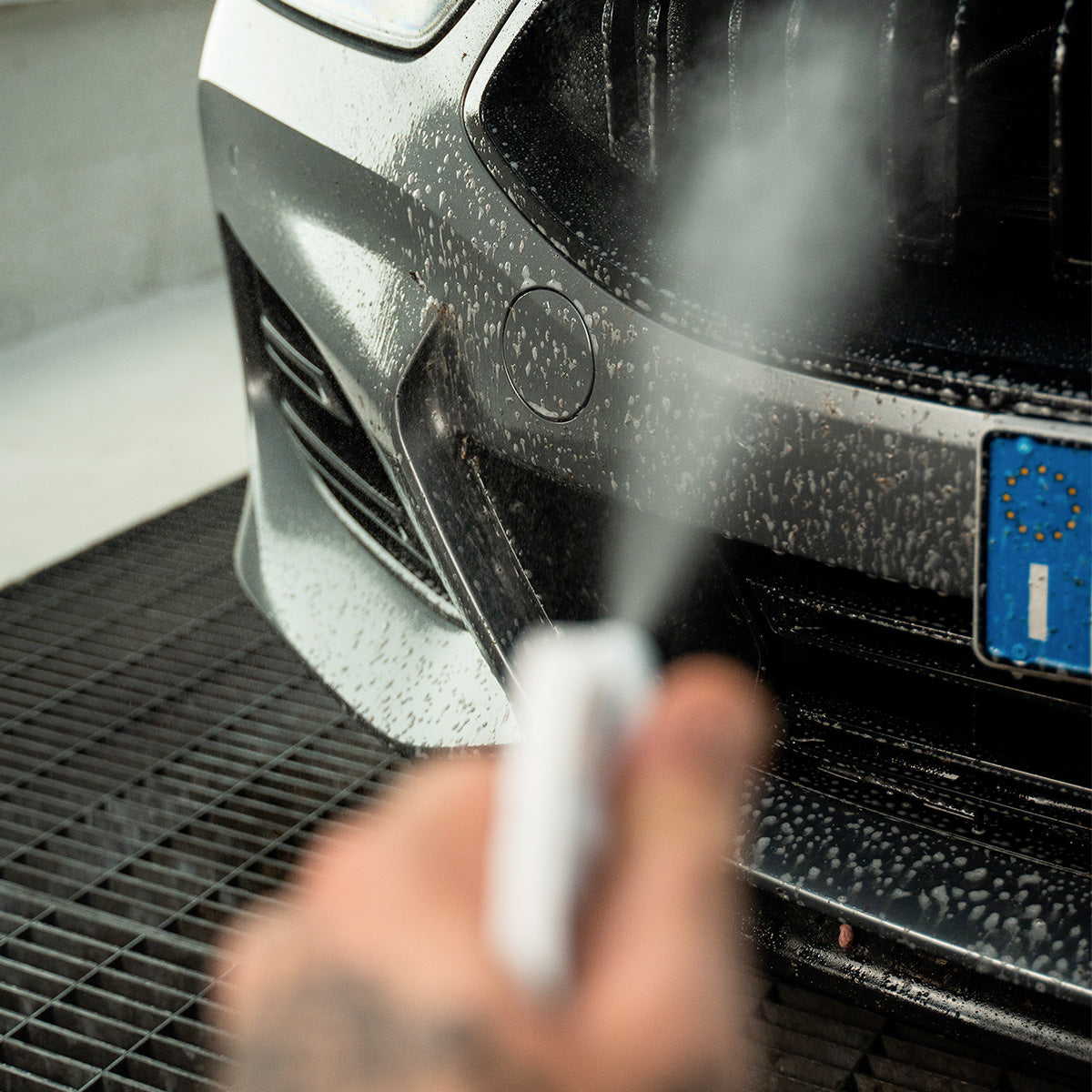 Vervuilde voorzijde van een auto wordt voorbehandeld met Labocosmetica